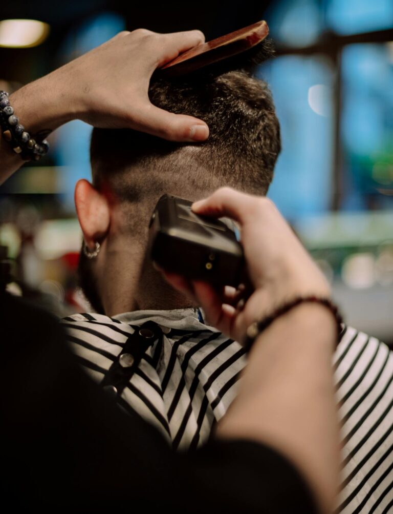 Back view close-up of a haircut in a Geneva barbershop, focusing on hairstyling tools in action.