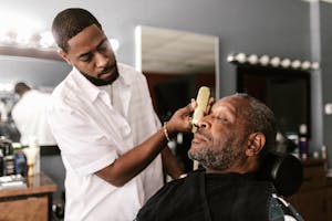 Barber using trimmer on client in a barbershop, capturing a moment of precision and care.